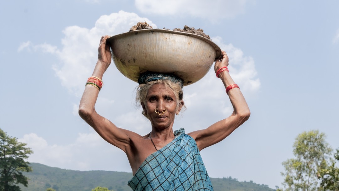 A woman carries a bowl on her head