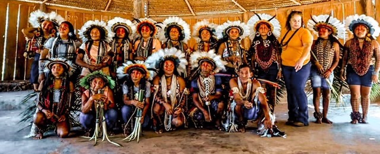 A group of indigenous people from the Rikbaktsa tribe pose in traditional dress for a group photo