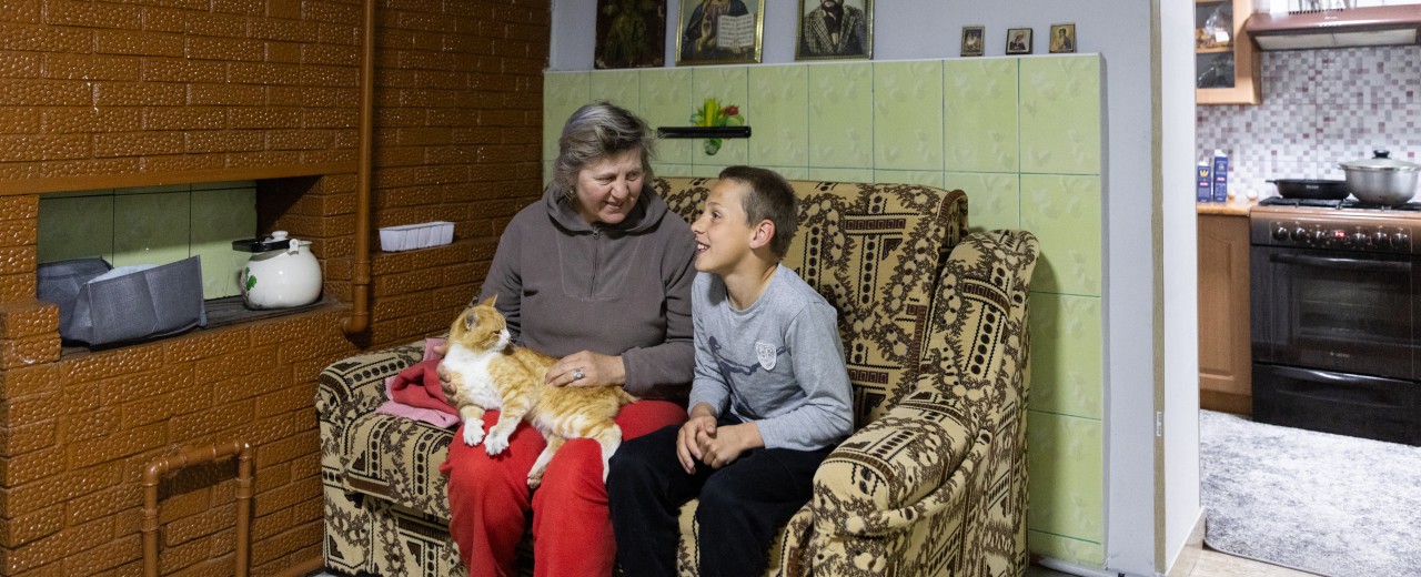 Ein Junge und eine Frau mit Katze auf einem Sofa