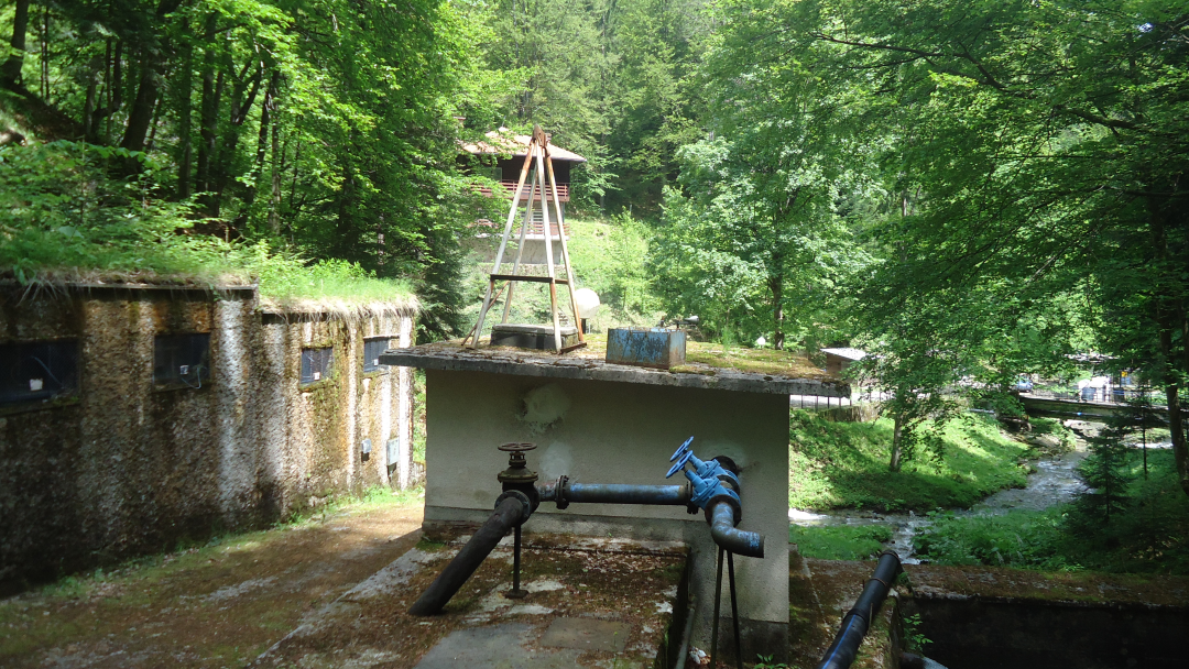 Wasseranlage mit Rohren und Bach im Wald