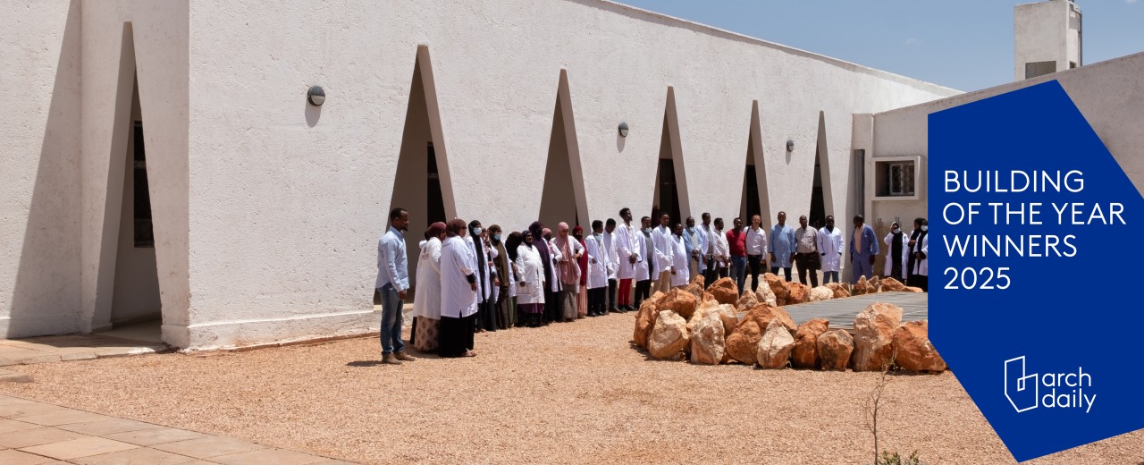 People in white coats are standing in front of the building.