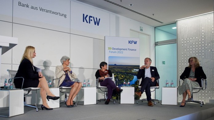 Five people in a discussion, KfW-Logo in the background