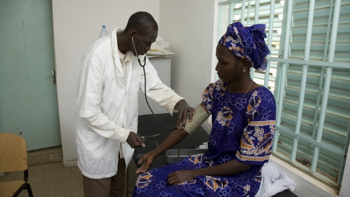 Arzt in einer Gesundheitsstation versorgt eine Patientin