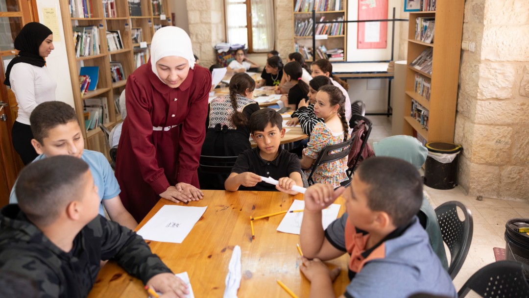 A teacher teaches school children in a classroom