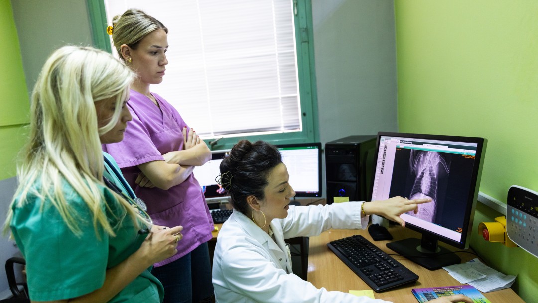 Drei Frauen blicken auf einen Computer 