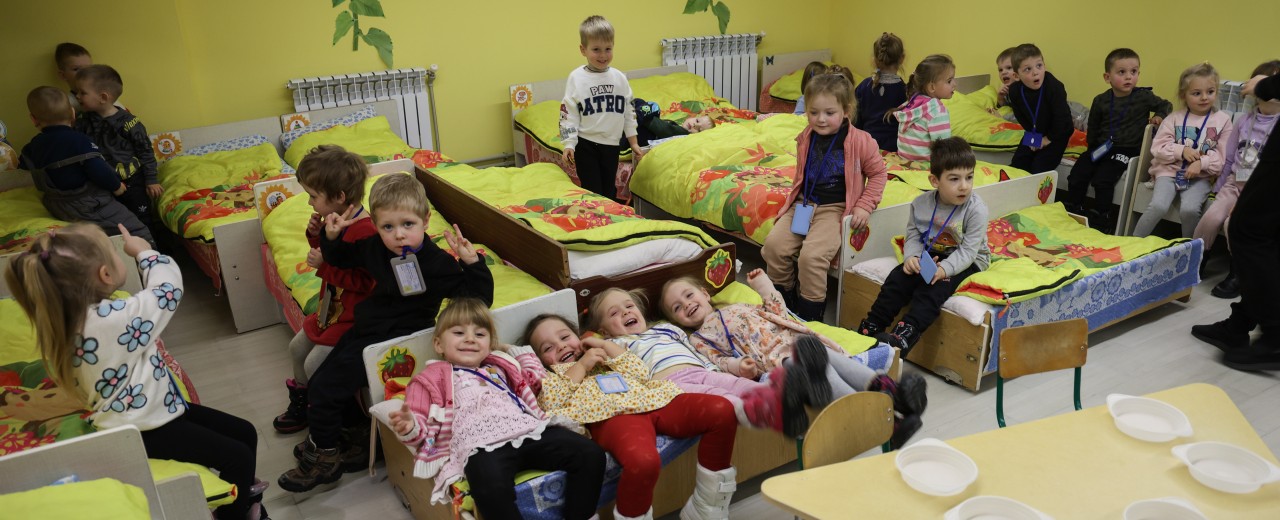 Kinder sitzen und liegen auf ihren Betten in einem Schutzraum eines Kindergartens in Schytomyr